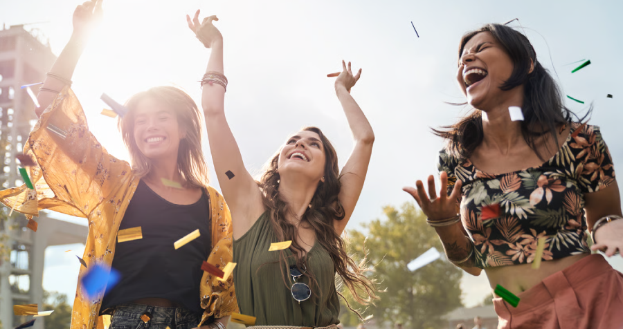 Cheerful Young Women Celebrating Together Outdoors