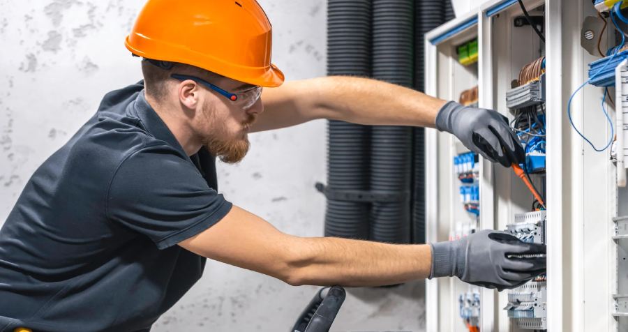 Electrician Repairing Wires Inside Electrical Box on Ladder
