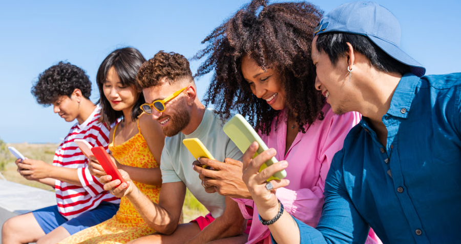 Friends Using Smartphones Sitting Outside on Sunny Day
