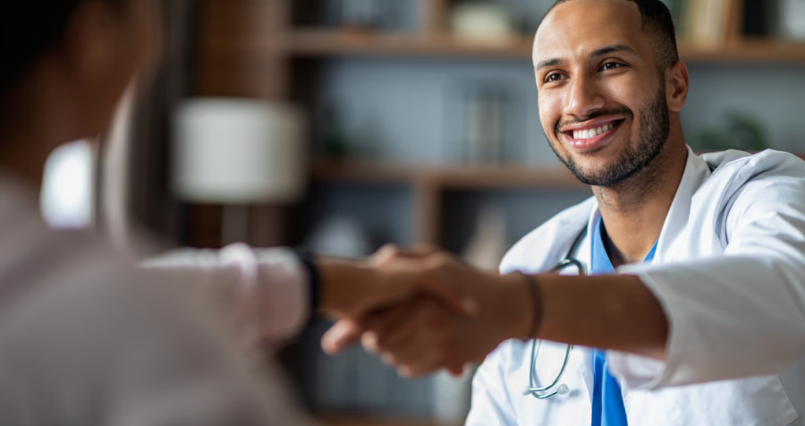 Smiling Doctor Shakes Hands with Patient at Office