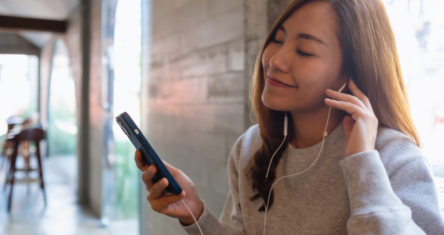 Woman Enjoying Music with Earbuds Indoors